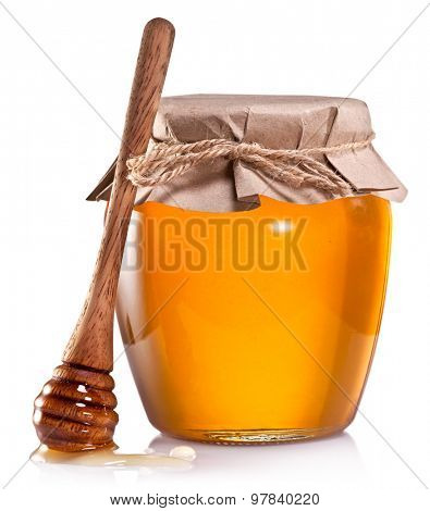 Glass can full of honey and wooden dripper on a white background.