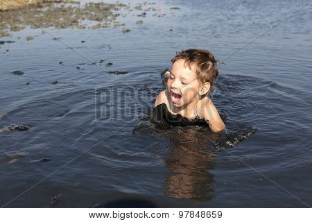 Boy Lying In The Black Mud