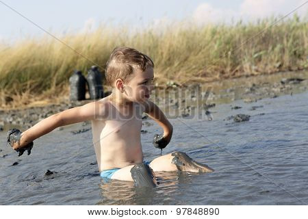 Child Sitting In The Healing Mud