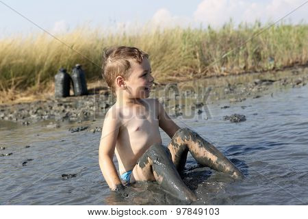 Kid Sitting In The Healing Mud
