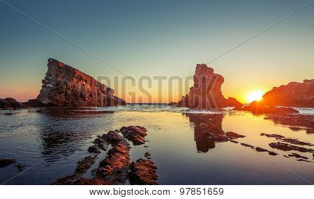 Dramatic Sunrise With Mist On The Beach With Rocks