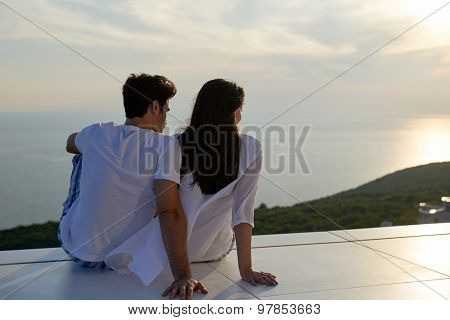 happy young romantic couple have fun relax smile at modern home outdoor terace balcony
