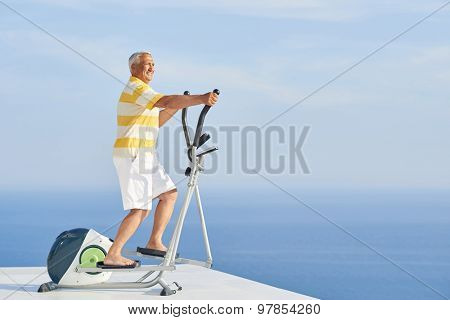 healthy senior man working out on gym treadmill machine at modern home terace with ocean view