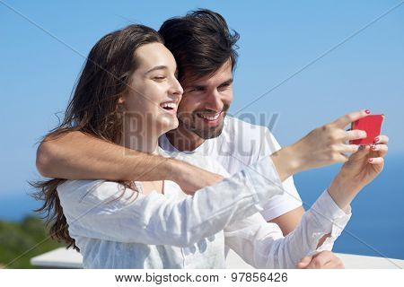 happy young couple taking selfie with cell phone