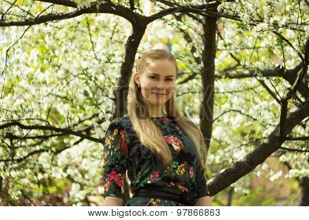 Beautiful woman standing near the apple tree