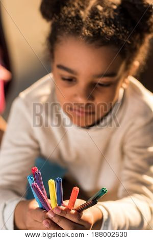 Close-up View Of Adorable Little Girl Holding Colorful Felt Tip Pens, Doing Homework Concept