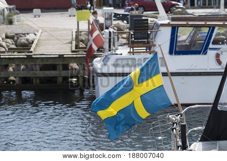 small swedish flag on a yacht in the Hundested harbor in Denmark