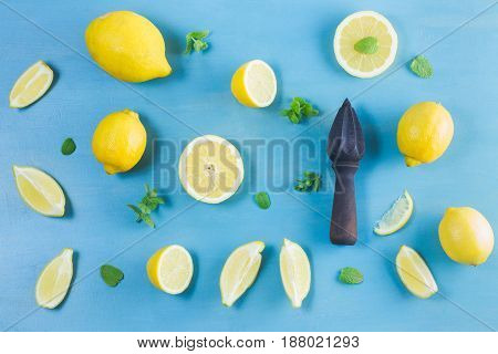 Fresh lemon citrus fruits with citrus reamer on blue bakground