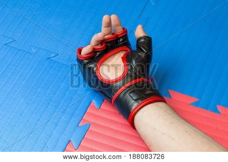Concept Of Defeat, Loss. Martial Artist Hand Wearing Mix Mma Open Fingers Gloves Touching The Tatami