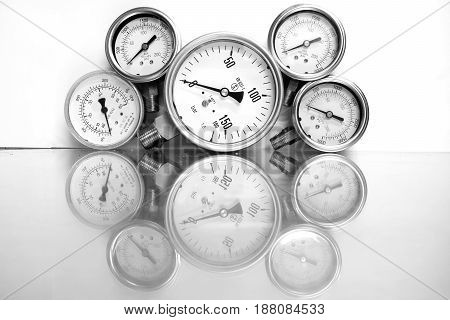 Row of metal steel high pressure gauge meters or manometers with brass fittings on tubing pipeline at LNG or LPG natural gas distribution station plant or factory facility isolated on white background.Pressure gauge in oil and gas production process.