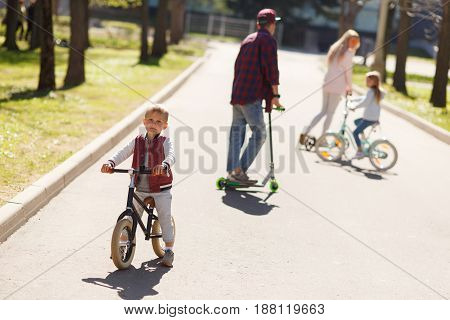Couple with children in active walk on scooters at park