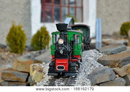 Beautiful realistic train model. Old red and green locomotion with wagons, train driver on metal rails. Slovakian tourist attraction in Cierny Balog