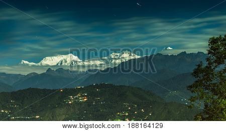 Beautiful panoramic view of moonlit Kanchenjungha Mountain Range of great Himalayas shot in a full moon night. Rinchenpong Sikkim India