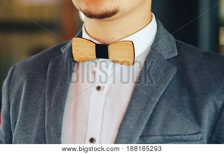 Stylish wooden butterfly at the groom at the wedding