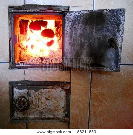 Photo of fire brown wood dark grey black coals on bright yellow fire inside metal brazier.Wood burning in the braziers.Flames fires preparation for cooking barbecue.Brazier of nature bbq background.