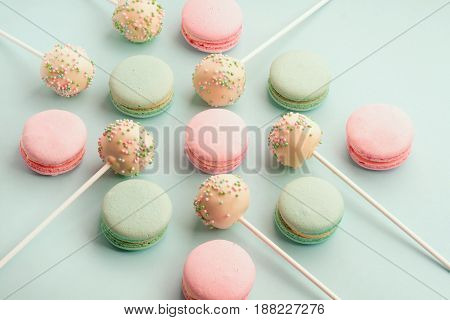 Sweet colorful macaroons with cake pops or cake crumbs with icing on sticks
