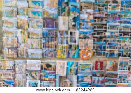 blur image of greeting travel colourful postcards on display in a store shelf as background.