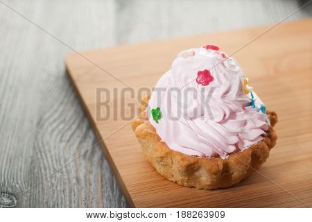 A Small Cake On A Wooden Table.