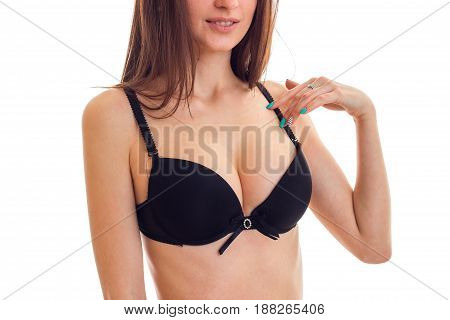 sexy natural breasts of a young girl in black bra close-up isolated on white background