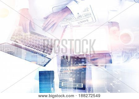 Top view of woman web designer working at her laptop in an office. Concept of IT work. City. Toned image double exposure