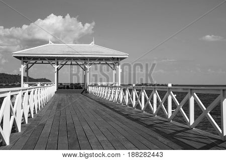 Black and White over wooden pavilion and walkway leading to ocean skyline background