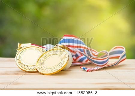 two old gold medal and golf ball on wood in morning soft background Winner concept