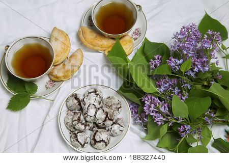 Cup of Tea with homemade chocolate breakfast cookies and spring flowers. Homemade biscuit. Sweet dessert pastry.