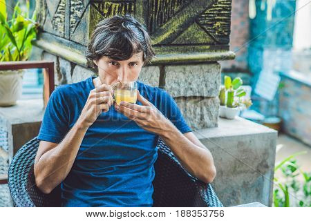Young Man Sitting In A Cafe Drinking A Delicious Morning Ginger Tea In A Cafe