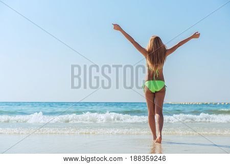 Sexy bikini body asian woman playful on paradise tropical beach having fun playing splashing water in freedom with open arms. Beautiful fit body girl on travel vacation. Banner crop for copy space.