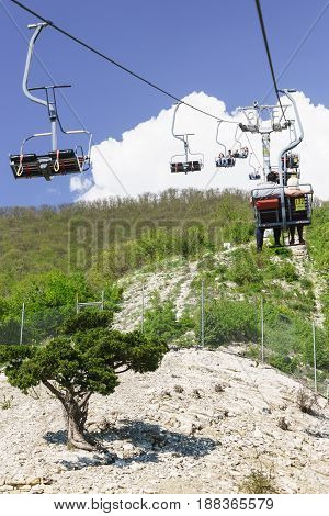 Gelendzhik Russia - April 30.2017: Tourists climb on the cable car over the spring and the of the Markotkh mountain range in the Safari Park.