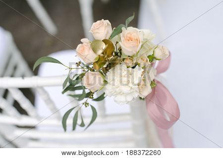 Pink ranunculus and roses buds in tenderless boutonniere with pink bow, closeup