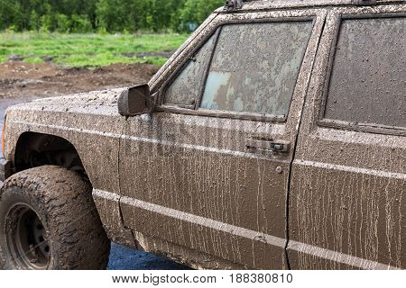 Dirty SUV after driving in the rain on extremely dirty rural road