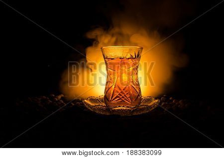 Turkish Azerbaijan Tea In Traditional Glasse And Pot On Black Background With Lights And Smoke. Armu