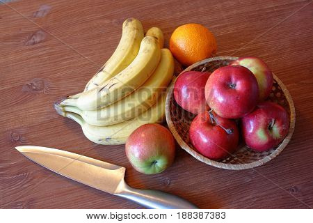 Fruit bananas apples orange on a wooden table background