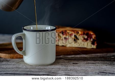 Fresh coffee in a white mug with a fruit pie