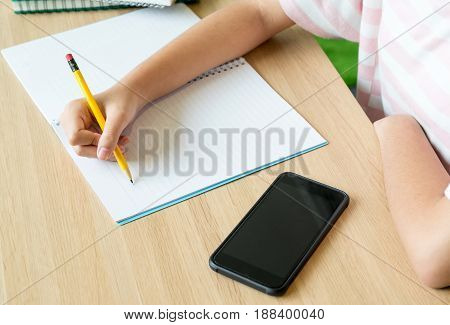 Close up hand of girl teenager learning online with mobile phone on wood tabele-learning education concept.