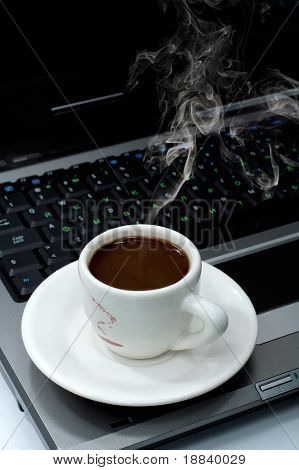 Taza de negro caliente humeante café en una laptop computadora negocios oficina ambiente concepto naturaleza muerta