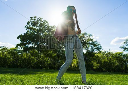 carefree girl with zizi cornrows dreadlocks dancing in the sunset on green grass of lawn