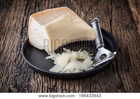 Cheese Parmesan . Parmesan cheese on old oak table with cheese grater.