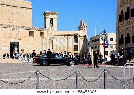 VALLETTA, MALTA - MARCH 30, 2017 - Politicians arriving in a limousine at the Auberge de Castille for a European Union conference with soldiers on parade in Castille Square Valletta Malta Europe, March 30, 2017.