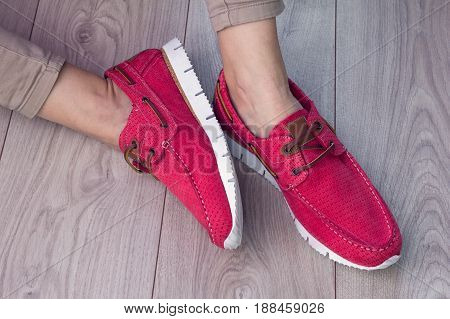 legs with a red leather moccasins on a laminate