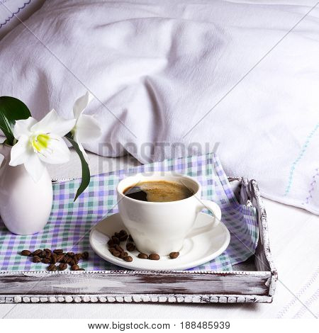 Cup of strong coffee with white flowers on rustic wooden serving tray. Tender love concept.Square