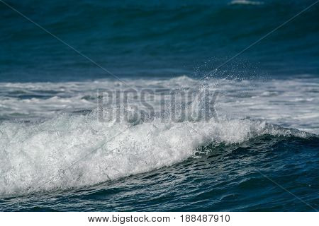 waves breaking into the shore in the late afternoon