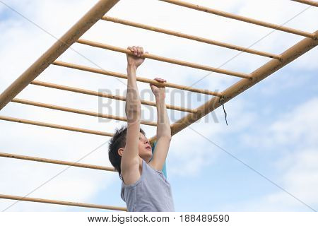 A Teenager In A T-shirt Is Engaged In Gymnastics On A Horizontal Bar