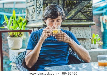 Young Man Sitting In A Cafe Drinking A Delicious Morning Ginger Tea In A Cafe