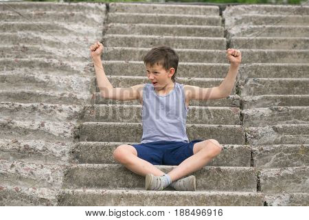 A Teenager In A T-shirt Sits On Concrete Steps
