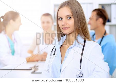 Happy doctor woman  with medical staff at the hospital sitting at the table and discussing medical history
