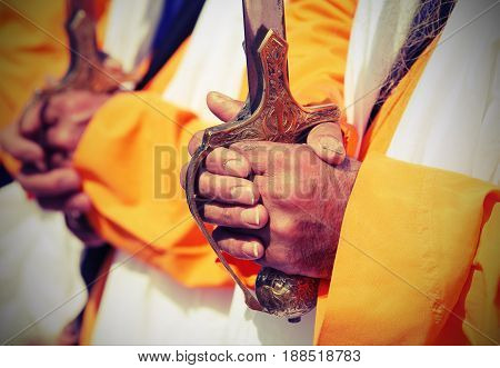 Detail of the hands of the Sikh religious men during the festival with vintage effect