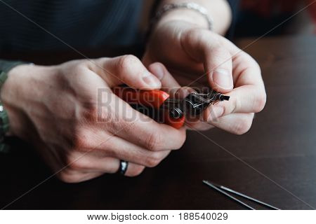 male master installs a coyle. Spiral for electronic evaporator and cigarette. Vape, vaping