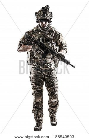 US Army rangers in combat uniforms with his shirt sleeves rolled up, in helmet, eyewear and night vision goggles moving walking towards camera. Studio shot, white background, dark contrast